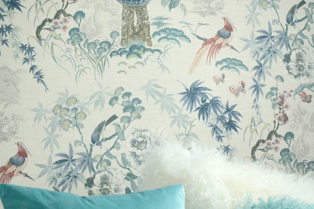 Decorative headboard with floral and bird pattern, teal pillows on a bed.